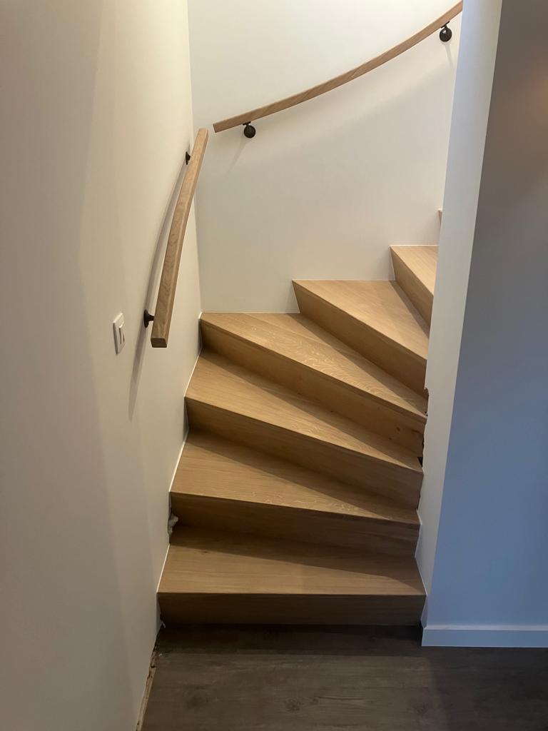 Featured image for “Houten z-trap tussen muren met houten handgreep”
