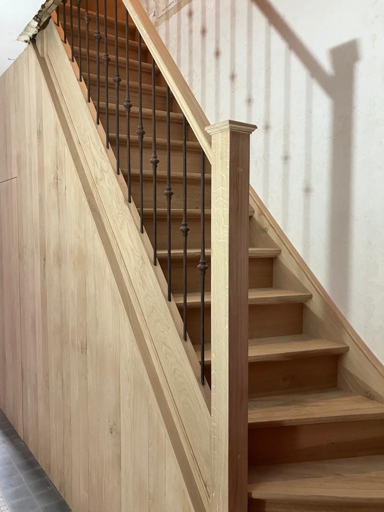 landelijke trap,smeedijzeren balusters,trapspijlen met roest kleuring,trappaal met hoedje,hout met noesten