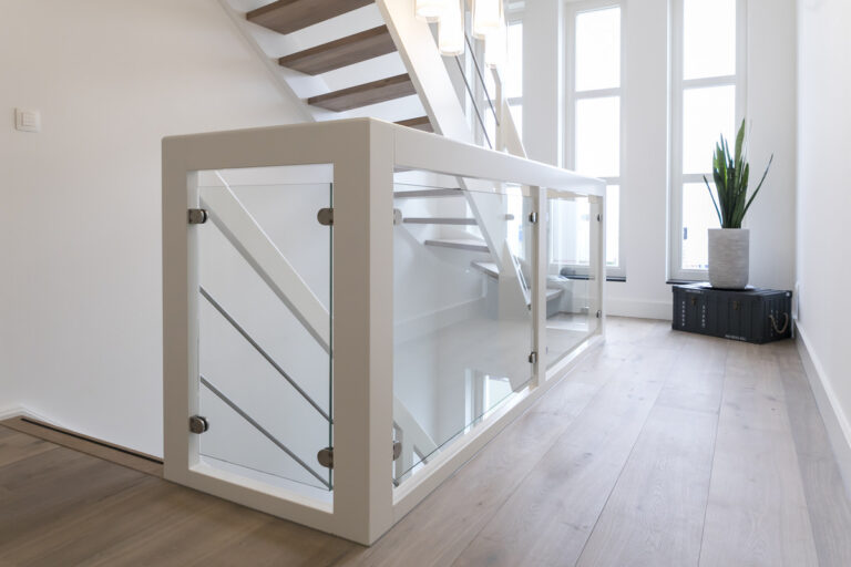 moderne trap in Woensdrecht, Nederland,detailfoto van de glazen balustrade op de verdieping,glas in combinattie met hout,ook zicht op de RVS spijlen evenwijdig met de handgreep op de balustrade