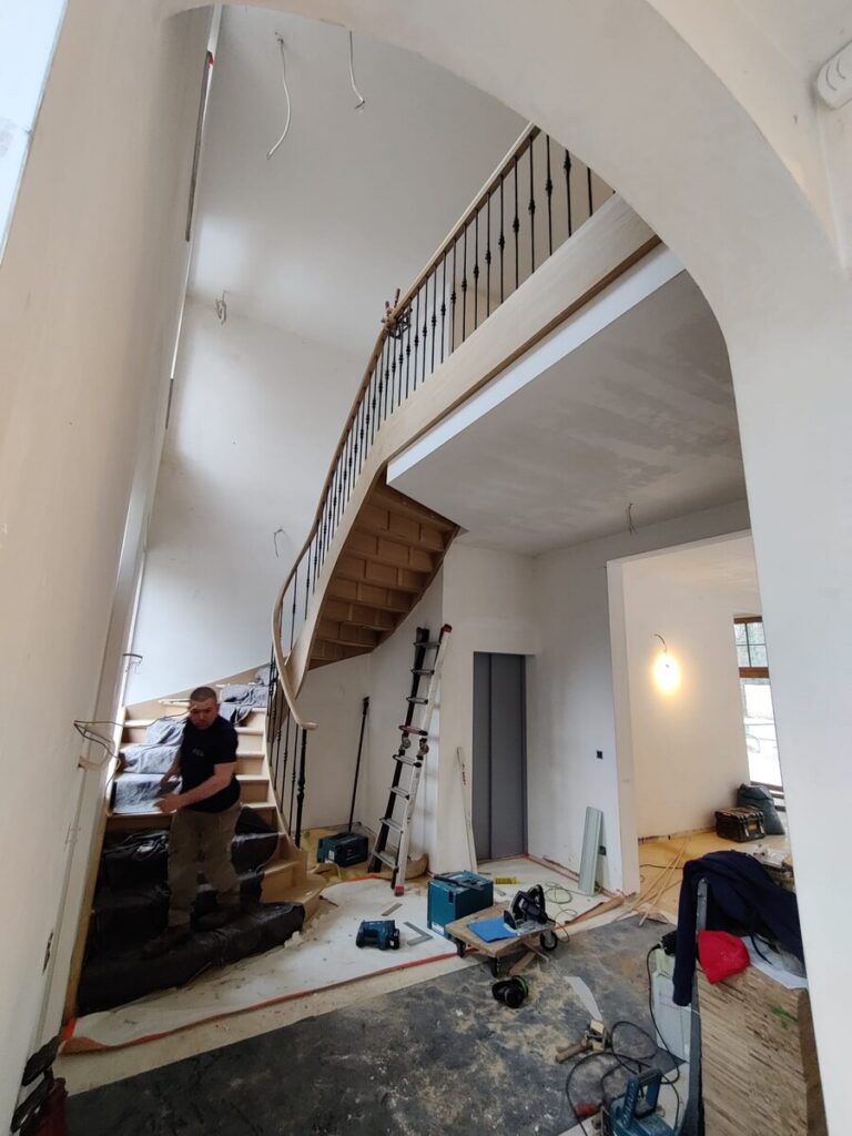 houten trap,klassieke trap,smeedijzeren hoofdtrappaal,smeedijzeren balusters,smeedijzeren trapspijlen,villa,trappenmaker,schilde,tijdens plaatsing