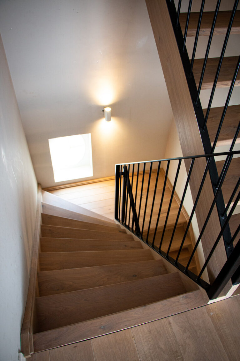 houten trap,moderne trap,stoere trap,modest plus,zwart metalen leuning,zwart gepoedercoat,rubio monocoat,zicht op bordes