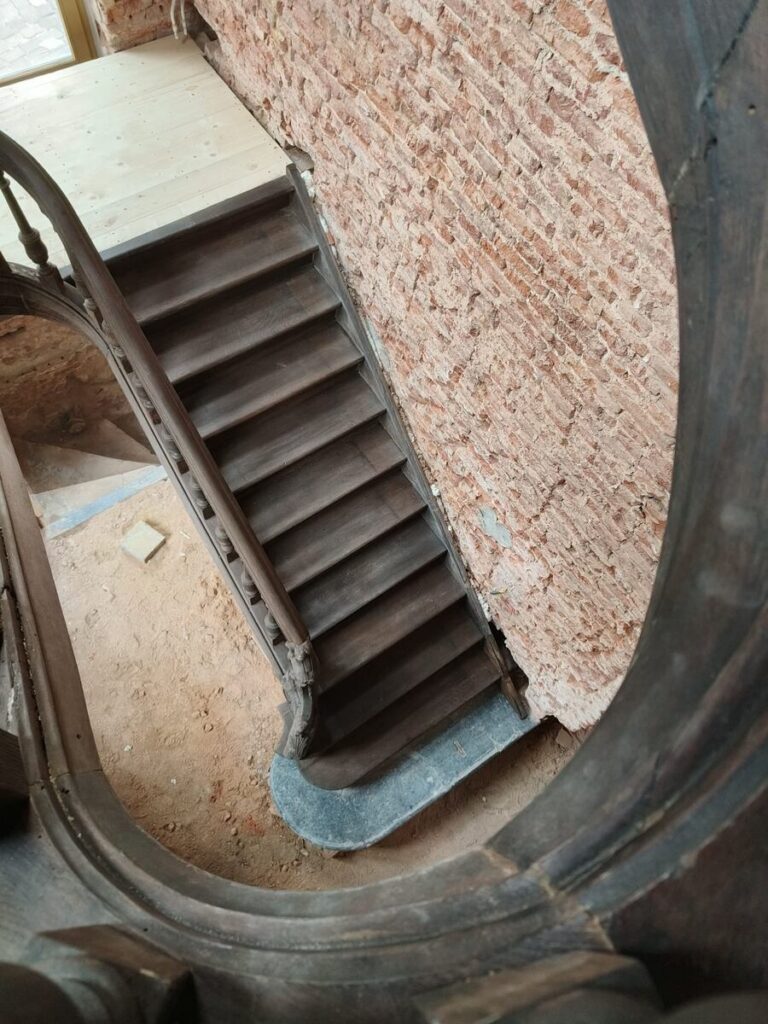 restauratie,oude trap,monumentale trap,klassieke trap,beschermd erfgoed,tervuren,Panquinkazerne,1749,in originele staat herstellen,gesloten trap met overstekende neus en treden tussen de wangen,de trap zelf is in Franse eik,trappaal met sculptuur,bloktrede bij aanvang,blauwe steen,bovenaanzicht