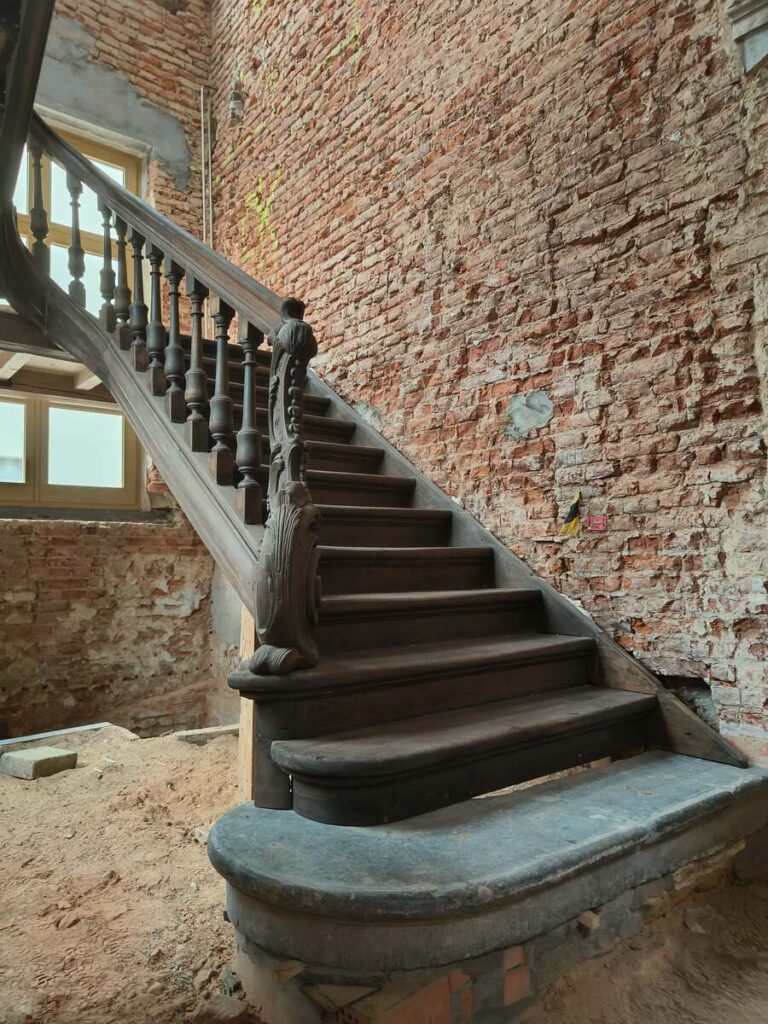 restauratie,oude trap,monument,historische trap,klassieke trap,beschermd erfgoed,tervuren,Panquinkazerne,1749,in originele staat herstellen,gesloten trap met overstekende neus en treden tussen de wangen,de trap zelf is in Franse eik,trappaal met sculptuur,bloktrede bij aanvang,blauwe steen