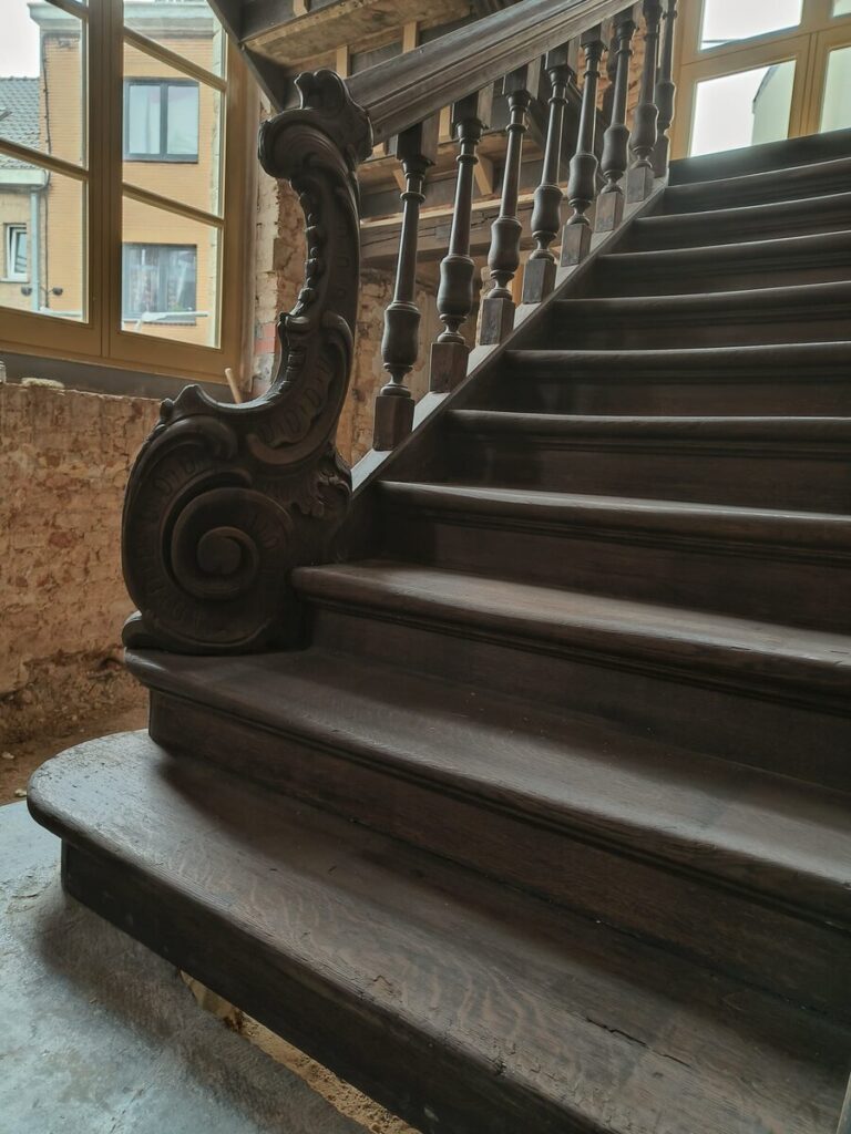 restauratie,oude trap,monument,historische trap,klassieke trap,beschermd erfgoed,tervuren,Panquinkazerne,1749,in originele staat herstellen,gesloten trap met overstekende neus en treden tussen de wangen,de trap zelf is in Franse eik,trappaal met sculptuur,bloktrede bij aanvang